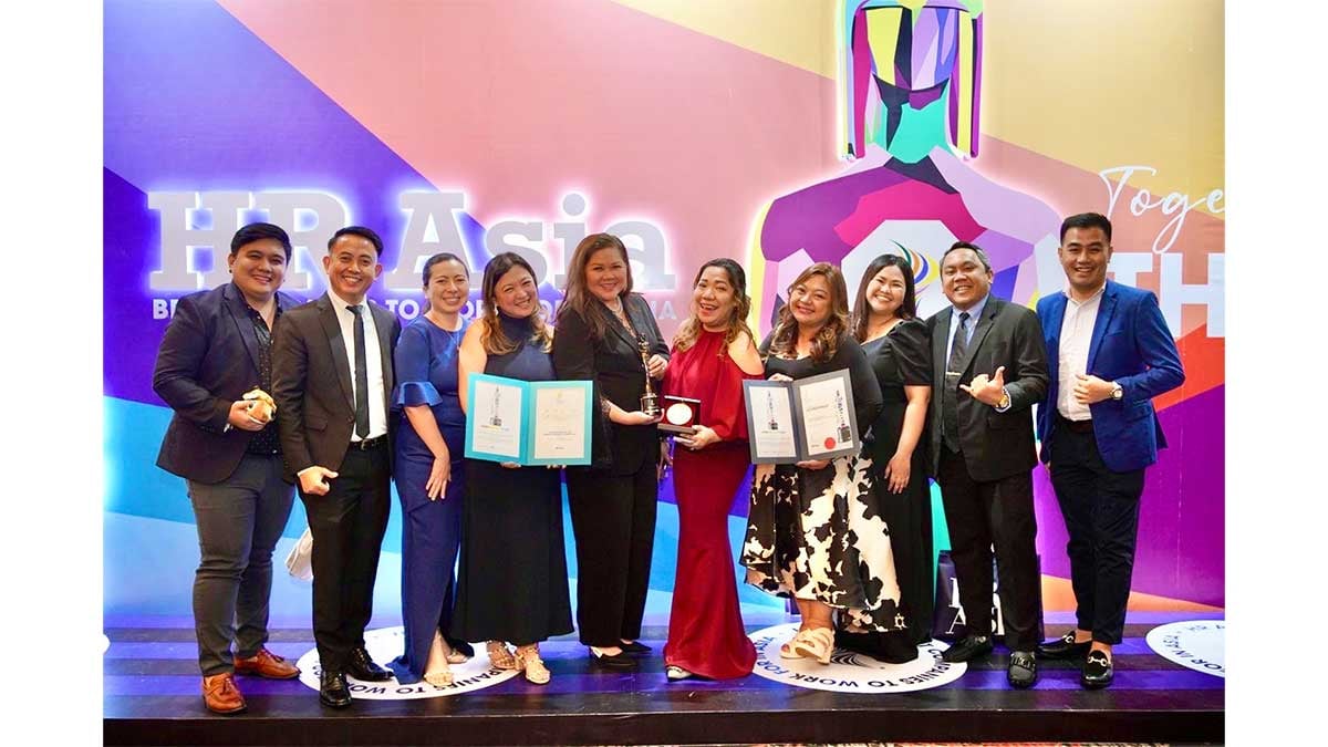 AIA Philippines chief human resource officer Ellen Imasa (5th from left) and staff pose on stage after receiving the Best Companies to Work For Award and Sustainable Workplace Award (inset) of HR Asia Awards.